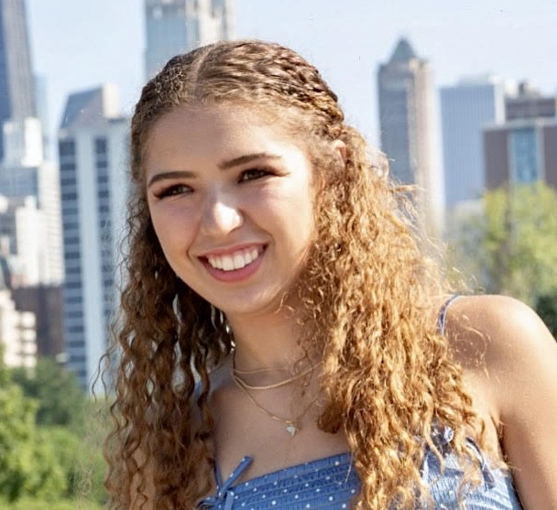 student smiling in front of a city background