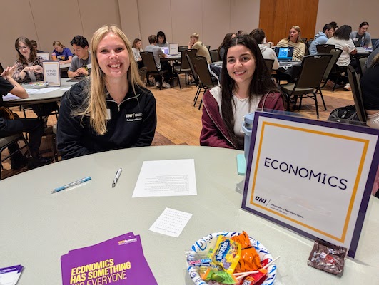 Two students sitting at the economics table at the Majors in Minutes event.