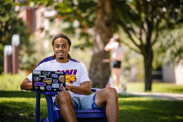 Student sitting in a purple lawn chair on campus